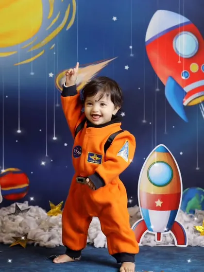 A joyful, dynamic shot of our little astronaut dancing among the stars. We encourage movement and play to capture the most natural and happy expressions.