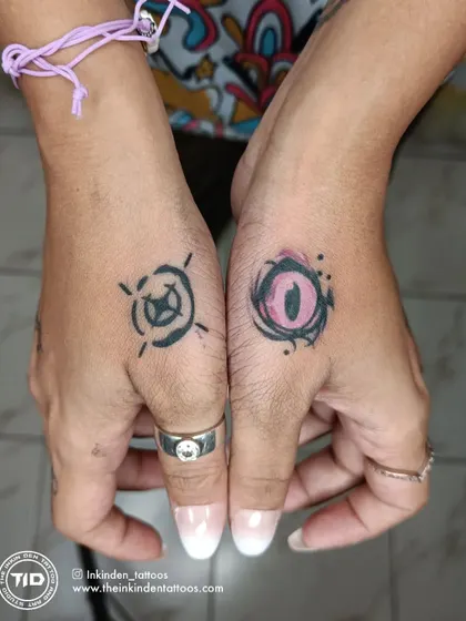 Matching hand tattoos for a Valorant fan, featuring the ability icons for the characters Reyna and Viper. These small, symbolic pieces are a creative way to show your love for the game.