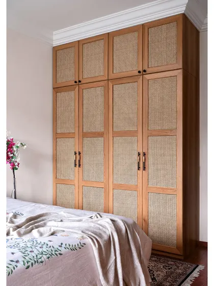In another bedroom, we used natural wood and rattan cane for the wardrobe shutters, creating a warm and earthy feel.