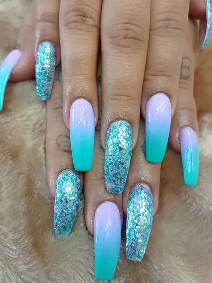 A mermaid-inspired set featuring a turquoise and lavender ombre with chunky turquoise glitter accent nails.