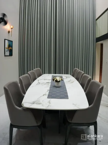 A full view of the ten-seater dining area, highlighting the scale and luxury of the space. The modern wall art and sconces add a touch of sophistication to the room.