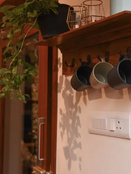 This handcrafted teak wood key holder is a perfect blend of style and function. It features hooks for keys and mugs, plus a small shelf for plants or mail, bringing warmth to your entryway.