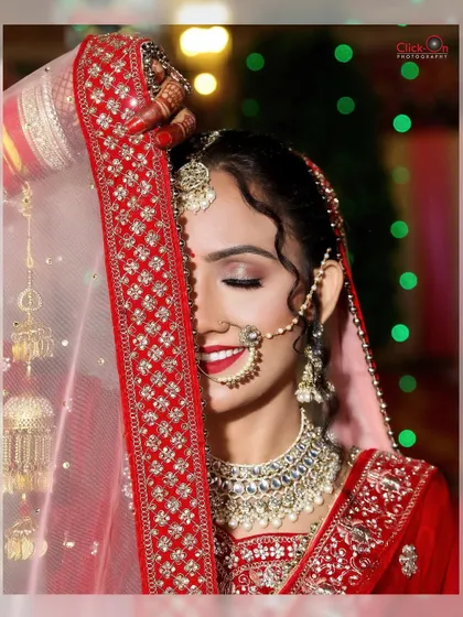 An artistic shot of the bride with her eyes closed, partially covered by her veil, highlighting her makeup and serene expression.