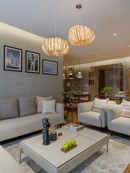 Another perspective of the living room, showing the comfortable arrangement of sofas and armchairs that encourage conversation. The space is unified by a soft rug and layered lighting from both overhead fixtures and ambient lamps.