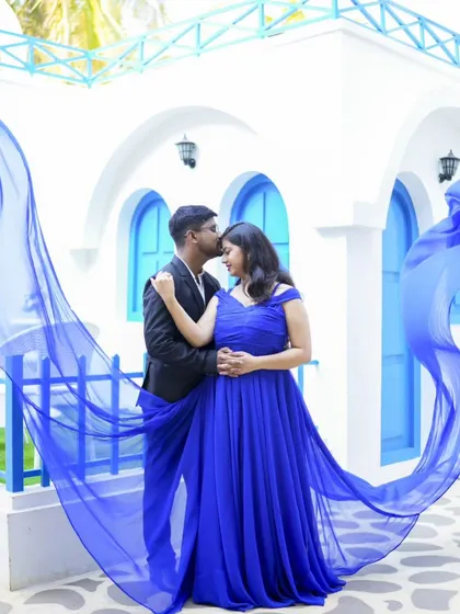 A stunning shot with a flowing blue gown creating a beautiful arc. This kind of dynamic photo adds a 'wow' factor to any pre-wedding album.