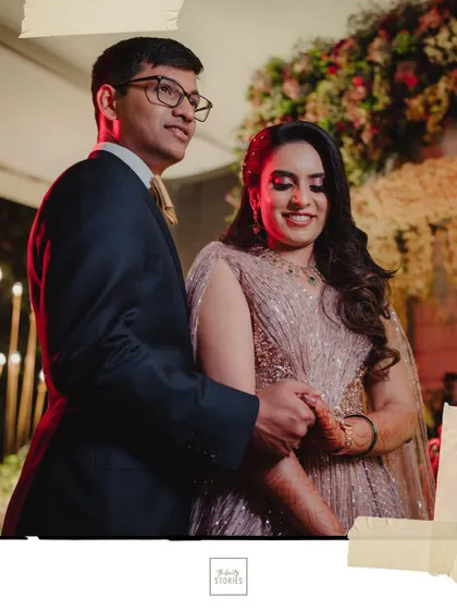 The couple stands together, holding hands and sharing a look, capturing a candid moment of connection during their reception.