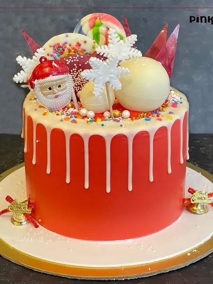 A festive Christmas drip cake, loaded with a Santa figure, snowflakes, and other holiday goodies. This cake is sure to be the star of your Christmas party.