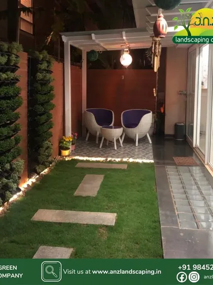 The same backyard space viewed at night, with subtle lighting along the vertical gardens and under the pergola, creating a warm and inviting atmosphere.