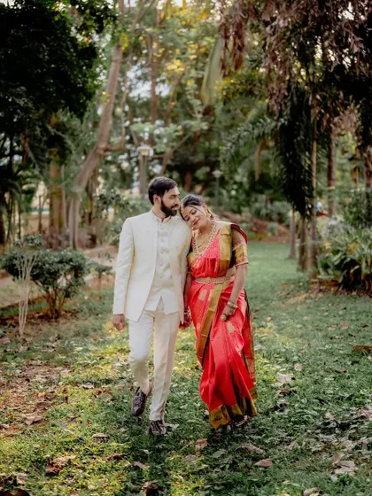 A candid walking shot, capturing the couple in mid-conversation. The bride's loving lean on her partner's shoulder makes this a sweet, natural moment.