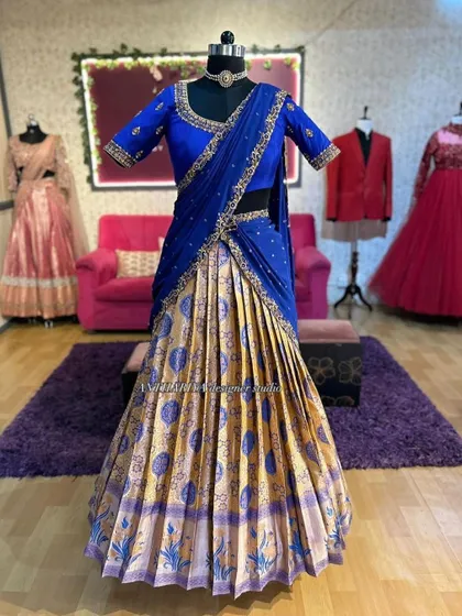 A frontal view of the royal blue and gold half saree on a mannequin. The pleats of the skirt and the elegant drape of the dupatta are clearly visible.