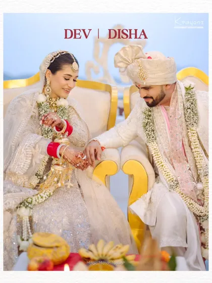 A beautiful portrait of the couple during their wedding ceremony, seated together as they begin their new life. Their coordinated white outfits add to the elegance of the moment.