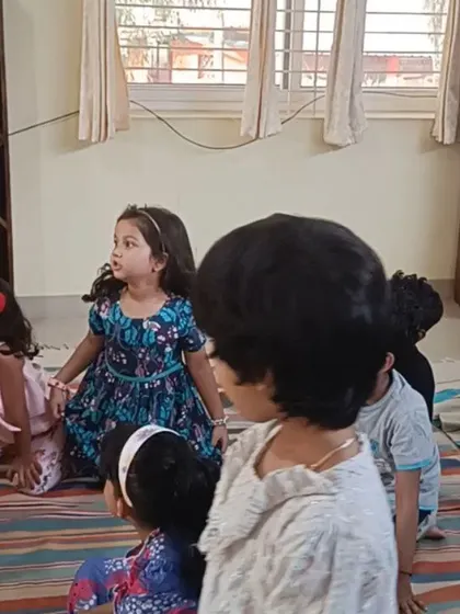 The children's faces are bright with anticipation as they listen to the story.