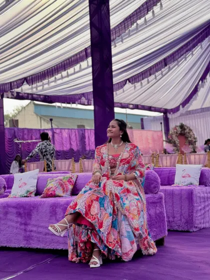 Taking a moment to relax on the plush purple sofas at the Haldi carnival venue.
