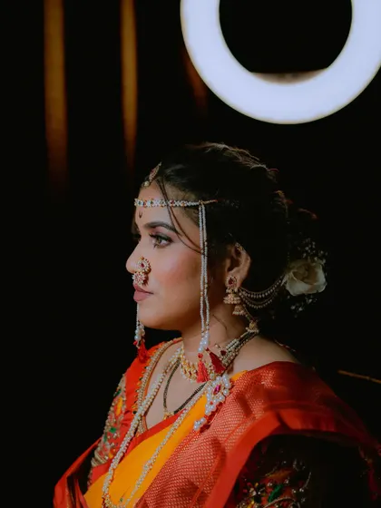 A beautiful profile shot of the bride, with dramatic lighting that accentuates her features and traditional accessories.