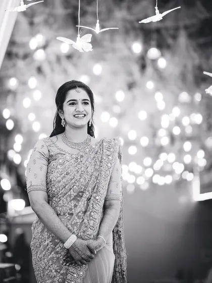 A stunning black and white portrait of the bride, her smile captured against a beautifully lit background.