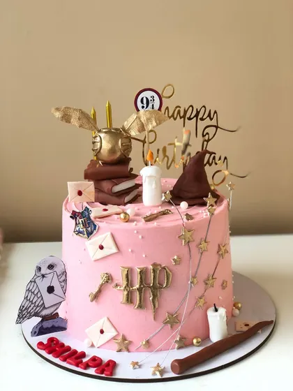 Another magical creation for a Harry Potter fan. This pink cake is adorned with golden details, a Hedwig topper, and acceptance letters from Hogwarts.