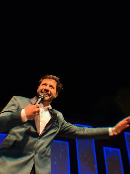 A candid shot of me on stage, mid-performance, with a huge smile. This is the authentic joy I bring to your most special occasions.