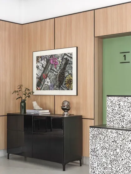 We used a harmonious blend of materials, including warm grey vinyl flooring, light oak laminate walls, and a black lacquered console, to create a sophisticated and calming atmosphere.