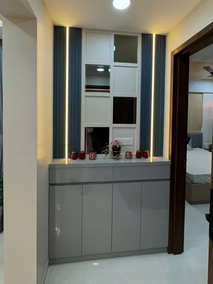 This entryway unit features a mirrored and paneled back wall with integrated lighting, adding a touch of glamour and making the space feel brighter.