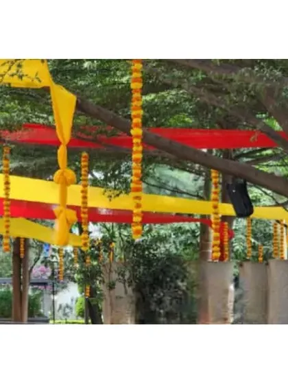 Another view of the outdoor festive decor, showing how the fabric strips and hanging marigold garlands are used to decorate the trees and create a canopy.