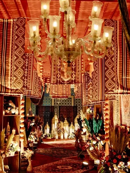 A view down the vintage bazaar entrance, with layers of rugs, warm lighting, and floral details creating a sense of depth and opulence.