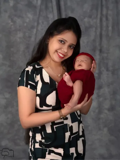 A proud and happy mother holding her precious newborn. Her smile radiates pure joy.