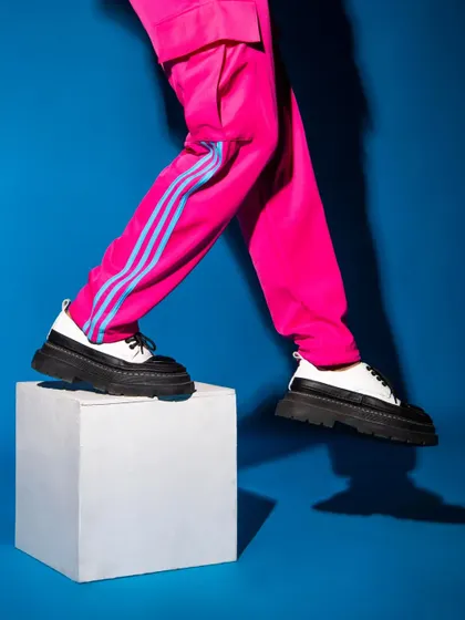 A detail-oriented shot focusing on the footwear and vibrant trousers. This kind of abstract composition is great for grabbing attention in an editorial spread.