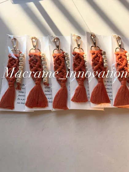 A set of personalized macrame keychains in a warm rust color, each customized with a different name. These make for wonderful and uniform gifts for a group.