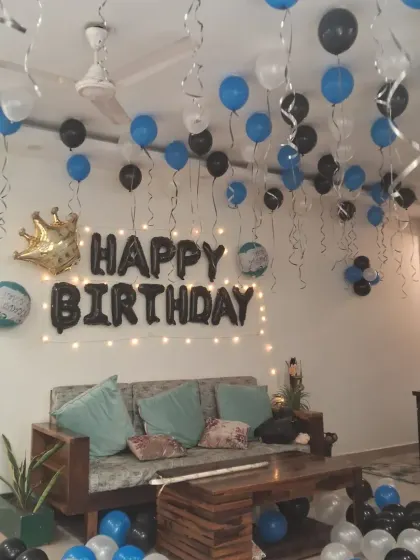 A wide view of the blue, black, and white birthday room decoration. The setup creates a festive and celebratory atmosphere in the living room.