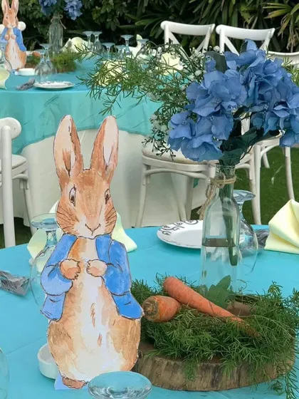 Another view of the adorable table centerpiece, with blue hydrangeas adding a pop of color to the Peter Rabbit garden theme.