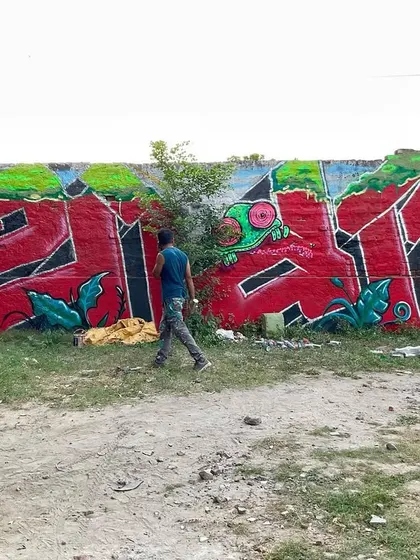 A full view of the 'शुभ' mural in its environment in Dwarka. The piece is about 350 sq. ft and was created using a mix of spray cans and emulsion paint.