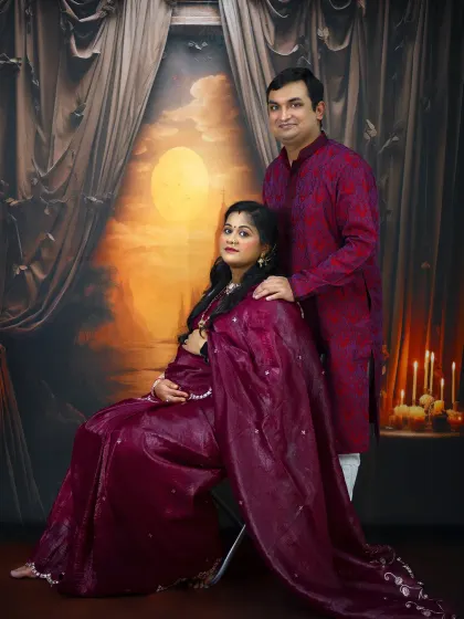 A classic, formal portrait of a couple in traditional Indian attire. The rich colors and dramatic lighting create a truly memorable and elegant image.