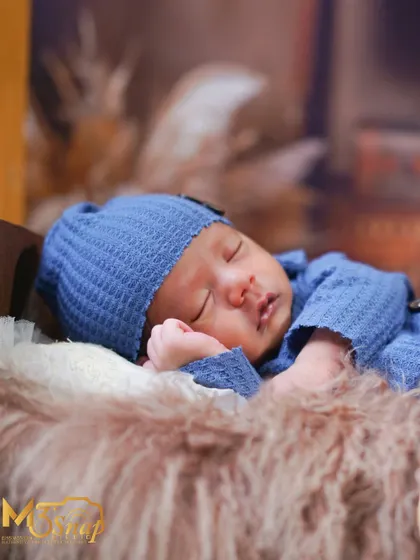 Another shot from the cozy blue series, focusing on the baby's serene expression as they dream.