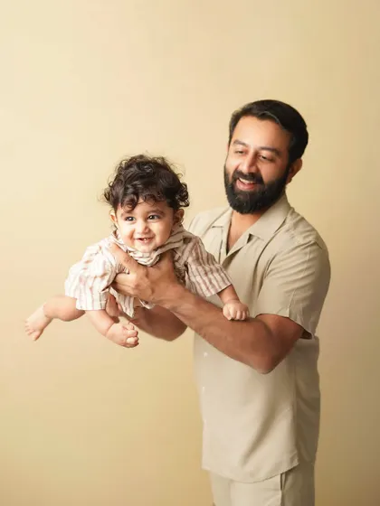 A father playfully lifts his son, both of them smiling. This photo is full of energy and the special bond between a dad and his boy.