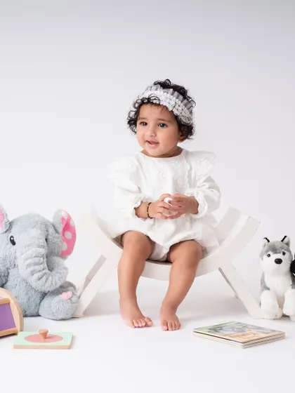 A wider shot of the sitter session setup. I use simple, clean backgrounds and a few favorite toys to create a space where the baby is the star of the show.