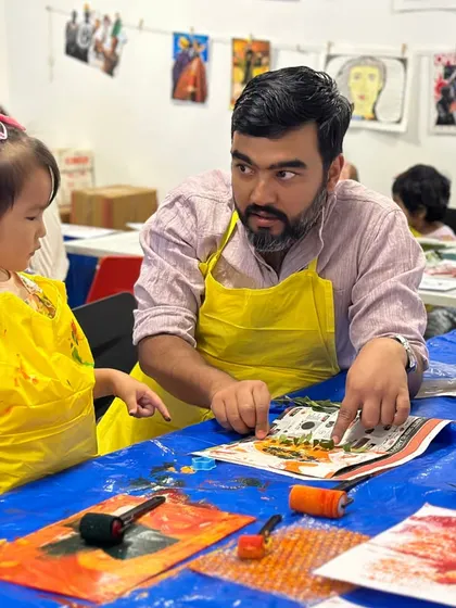A father guides his daughter through the printmaking process. These moments of shared learning and discovery are at the heart of my family-focused workshops.