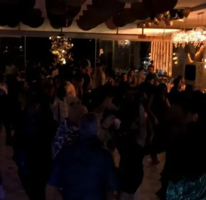 A darker, more intimate shot of the corporate party, with guests enjoying the music.