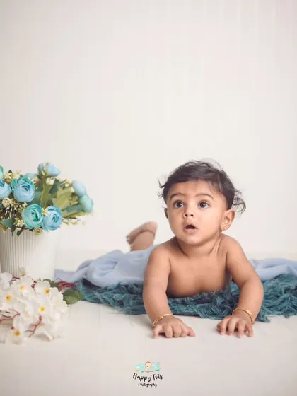 Sometimes the most minimal pictures are the best. This tummy time shot on a clean floor with just a few flowers shows off the baby's natural cuteness.