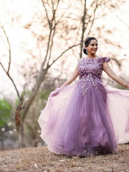 An outdoor shot featuring a flowing purple gown. The natural, golden-hour light creates a dreamy and romantic feel, perfect for evening wear lookbooks.