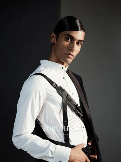 Complete your look with statement accessories that speak volumes. This leather harness, worn over a crisp white shirt, is designed for the man who understands the power of detail.