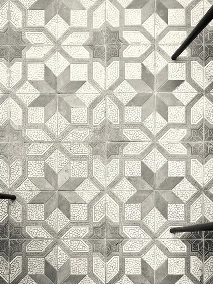 The geometric, star-patterned floor tiles we used in the Jollygunj bar. This top-down shot highlights the graphic quality of the flooring, which adds a layer of visual interest to the space.