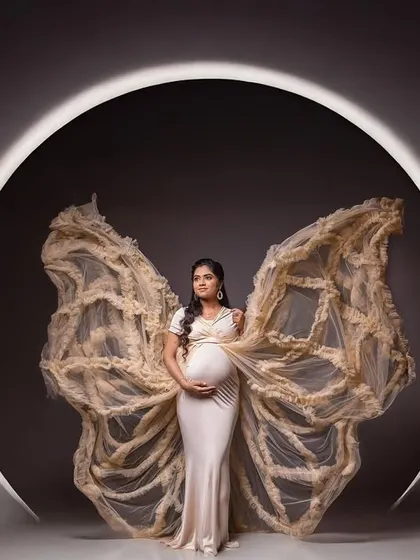 A stunning studio portrait using our butterfly wings prop against a circular light, creating a dramatic and angelic effect.