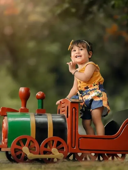 A sweet, shy moment during her toy train photoshoot. Even the quiet moments are beautiful, showing a different side of your child's personality.