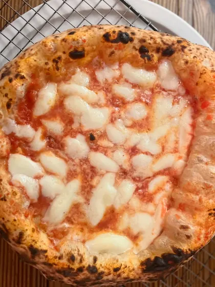 A perfectly baked Margherita resting on a cooling rack. This helps keep the bottom crisp so your first bite is as good as the last.