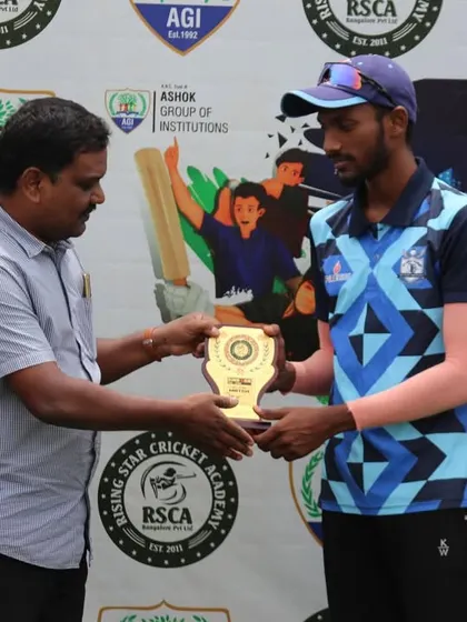 An official presents an award to a player for his contribution during the T20 match.