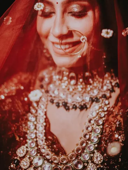 An artistic close-up of a smiling bride under her veil, with a soft, dreamy focus.