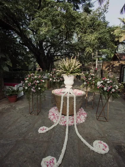 A stone well decorated with jasmine garlands and floral arrangements, a unique and beautiful decor element.