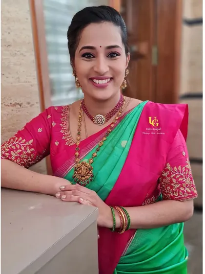 The lovely Sindhu with a bright, happy smile. Her subtle makeup with a pop of pink on the lips perfectly complements her vibrant green and pink silk saree.