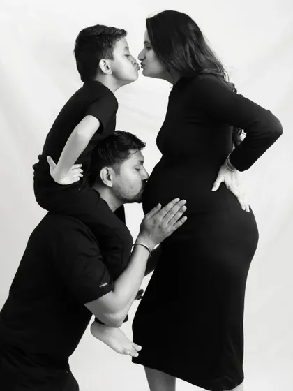 A beautiful black and white portrait celebrating your growing family. This maternity photo captures the love and excitement from everyone, including the big brother to be, as you await your new arrival.