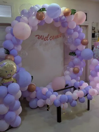 A chic and modern welcome baby setup with a circular balloon arch in pastel lavender and pink. This elegant design is perfect for a stylish celebration.